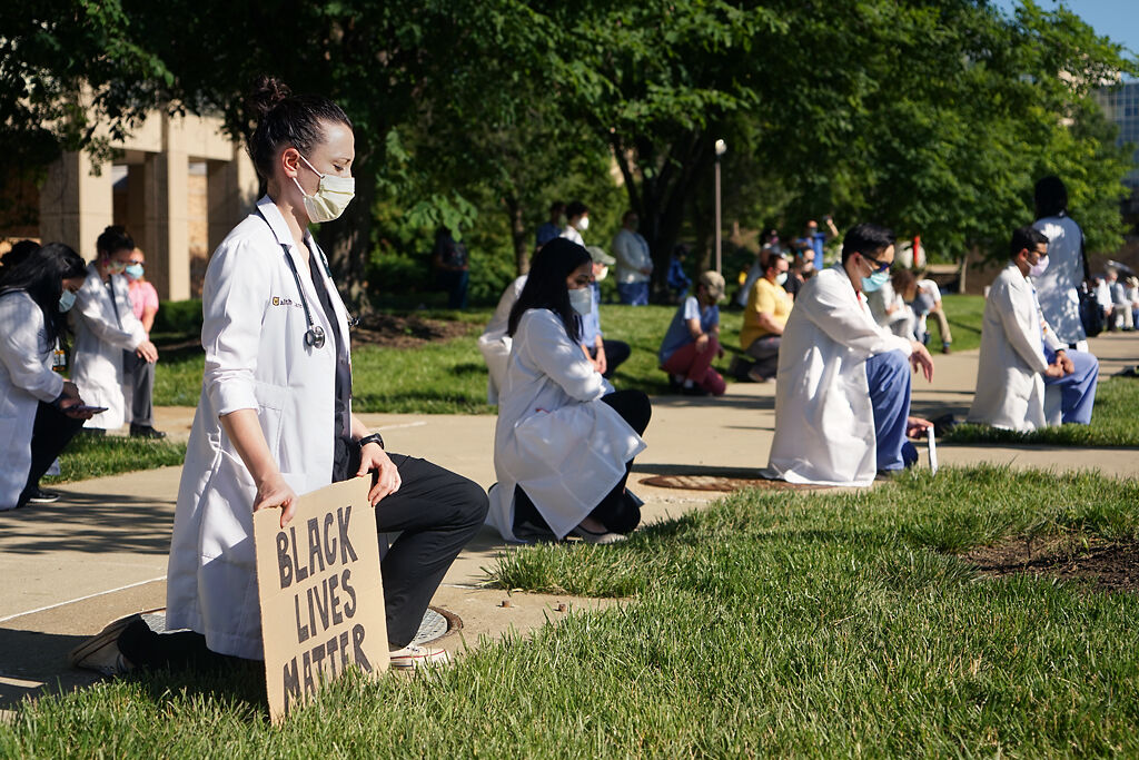 Associate professor Mary-Beth Bernardin kneels and reflects during the moment of silence demonstration